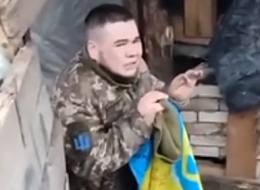 RU soldiers harass a captured UA soldier