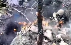 Russian soldier tries to put out a fire on his position and on himself