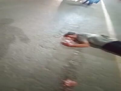 The biker struck his head on a large vehicle's wheel.