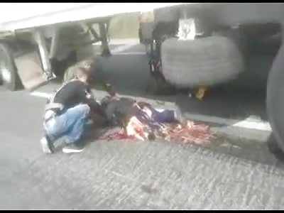RIDER WITH CRUSHED BODY, STILL ALIVE UNDER TRUCK TIRES