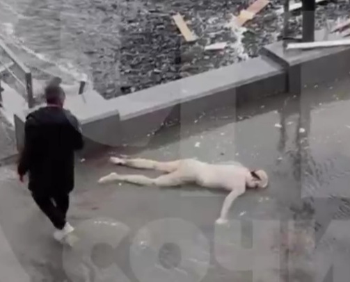 naked dead man with a broken head, who washed up on the beach  