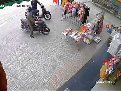 Unsuspecting dude chilling on his scooter gets taken out by car.