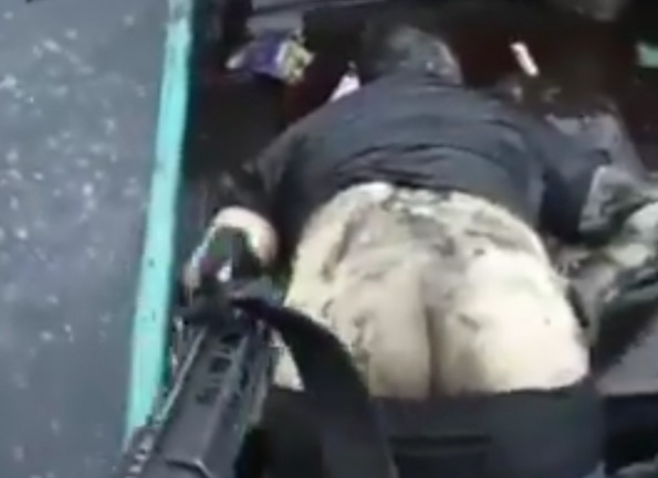 Armed criminals showing dead rival in boat 