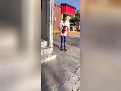 A man walking with a knife buried in his abdomen 