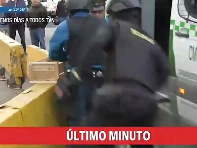 A female criminal takes the guard's gun and shoots them.