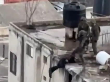Israeli soldiers throwing Palestinians dead bodie from top of bulding 
