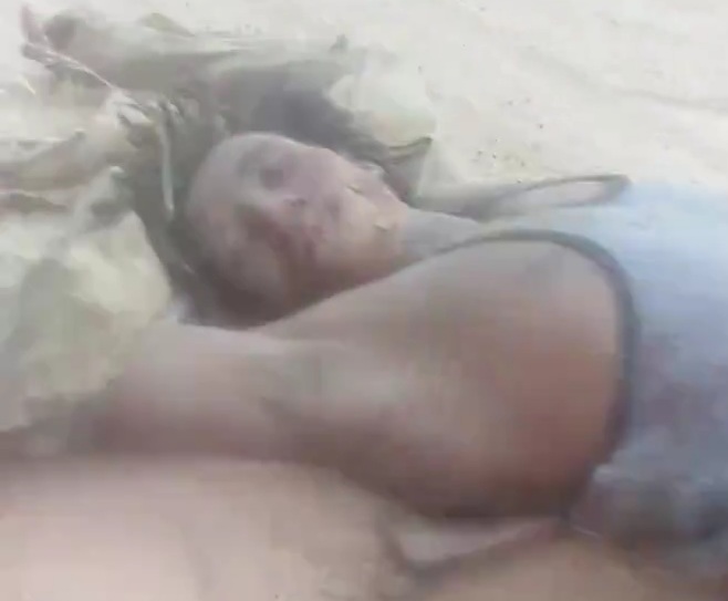 Sudanian soldiers dragging two dead militia members 