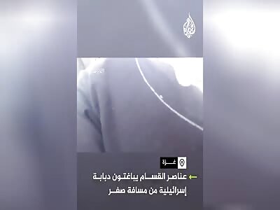 A Qassam fighter places a bomb under a Merkava tank.