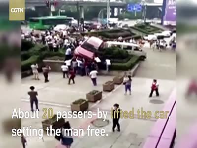 Passers-by lift car to rescue man trapped underneath