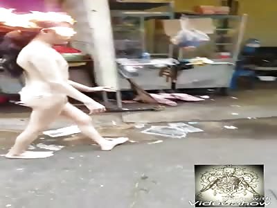 young crazy asian burn his head and dance in the middle of the street