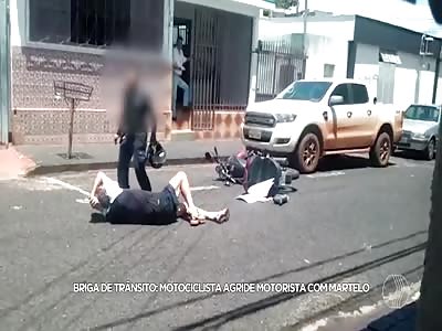 car driver lets motorcyclist hit him on the head with a hammer