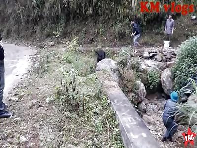 man butches a cow with a axe in Laos