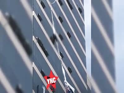 a man holding on to a banner outside of a high rise building in  in Gyeonggi-do, South Korea