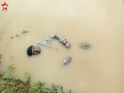 dead youth floating in the drain next to the Ladukai Haat market 