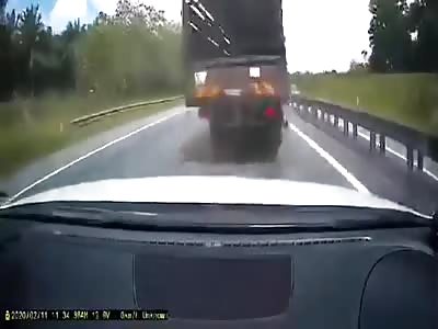 Truck tire blowout causes car crash and rollover.