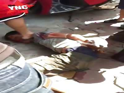 Stepping on the face of a bound and bloodied thug