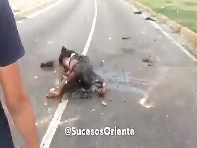 Protesters throwing rocks at a burned body