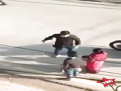 young man is beaten with a stick in front of his mother