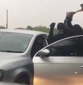 Gang with hatchet attack man in car while driver waits.