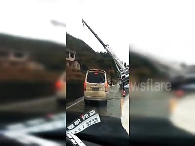 Two men narrowly escape being buried by crane falling over on road