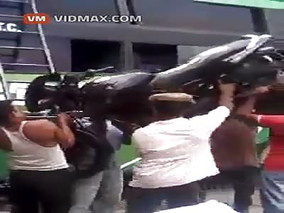 Indian guy lifts a motorcycle up a ladder, on his head!